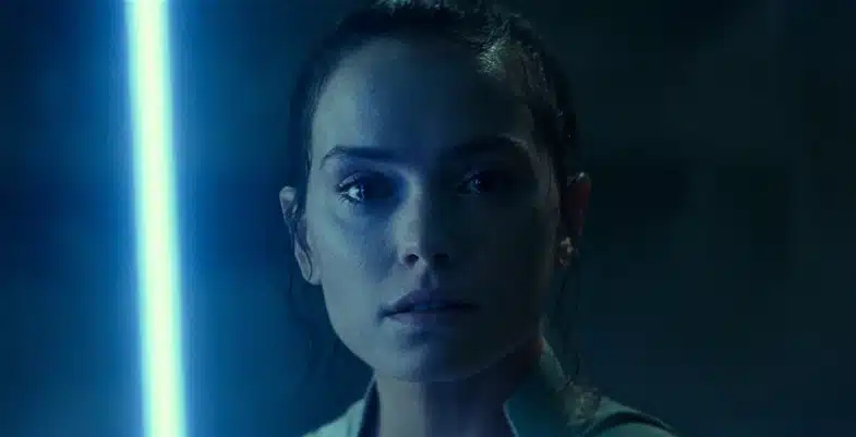 Rey Skywalker, le sabre laser bleu allumé, dans une scène sur Exegol.