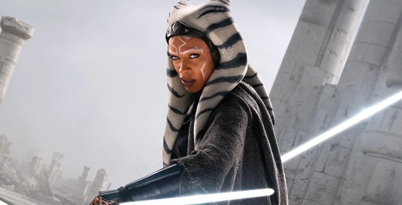 Ahsoka Tano, tenant ses deux sabres lumineux, se tient prête devant des ruines antiques.