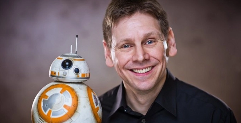 Brian Herring portant une versions plus petite de BB-8 sur la main.