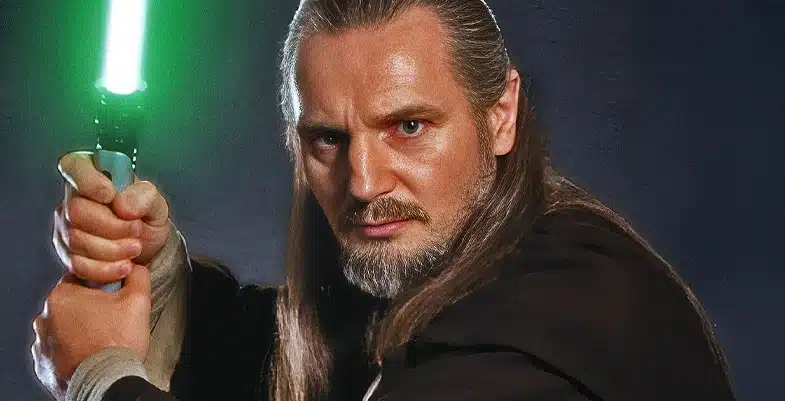 Qui-Gon Jinn avec un regard intense portant son sabre laser à lame verte sous un fond gris/bleu.